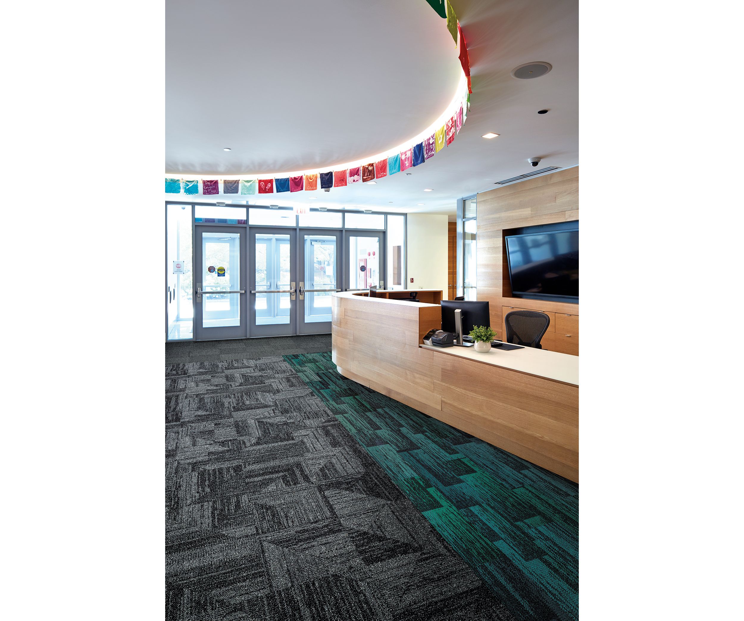 Interface Open Air 403 carpet tile in front desk area with multi color small flags overhead imagen número 2